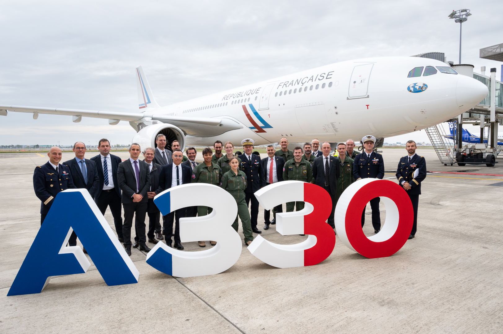Le comité d'honneur pose devant un signe "A330" devant l'aéronef A330, sur le tarmac