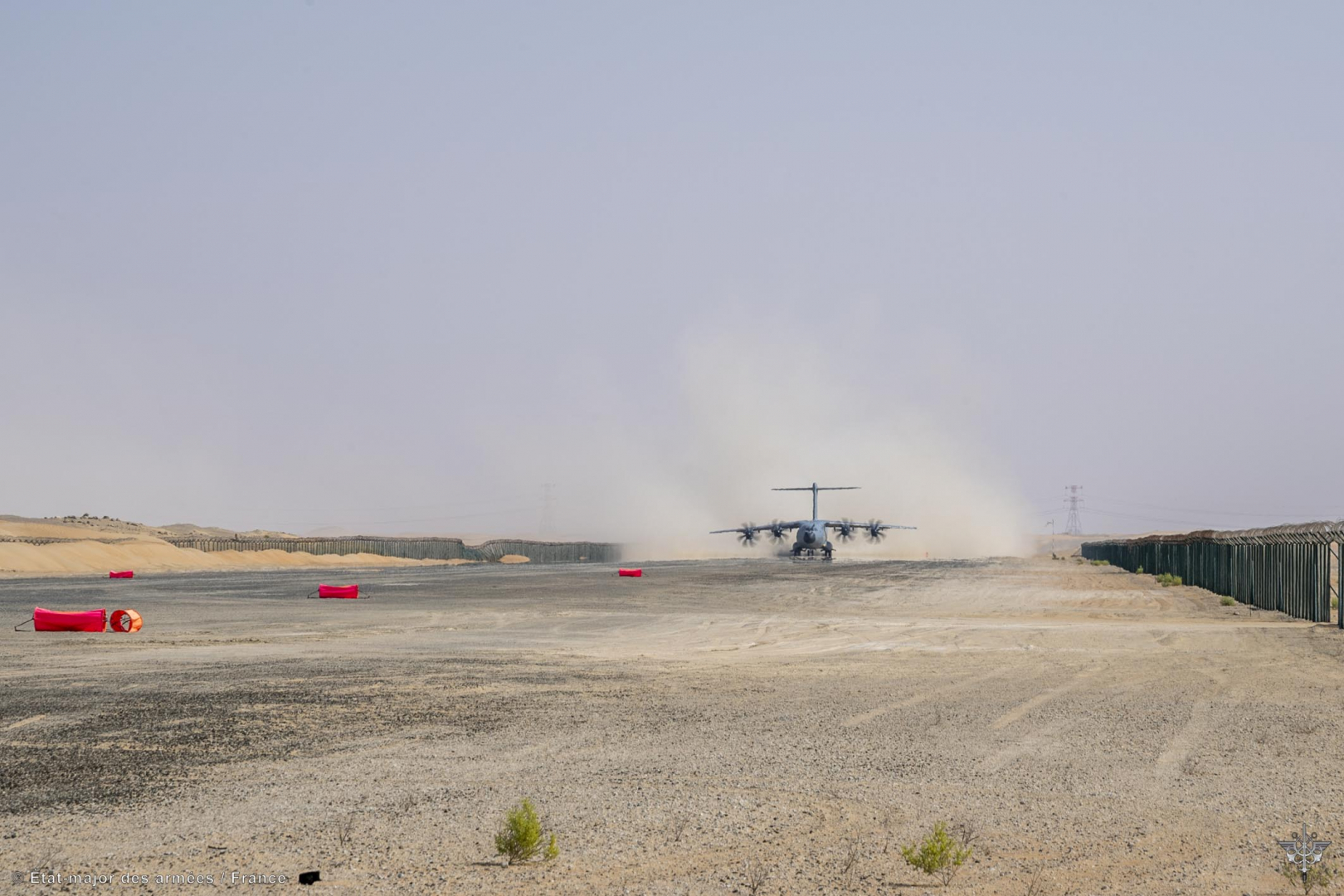 Au loin, un A400M dans le désert, au sol