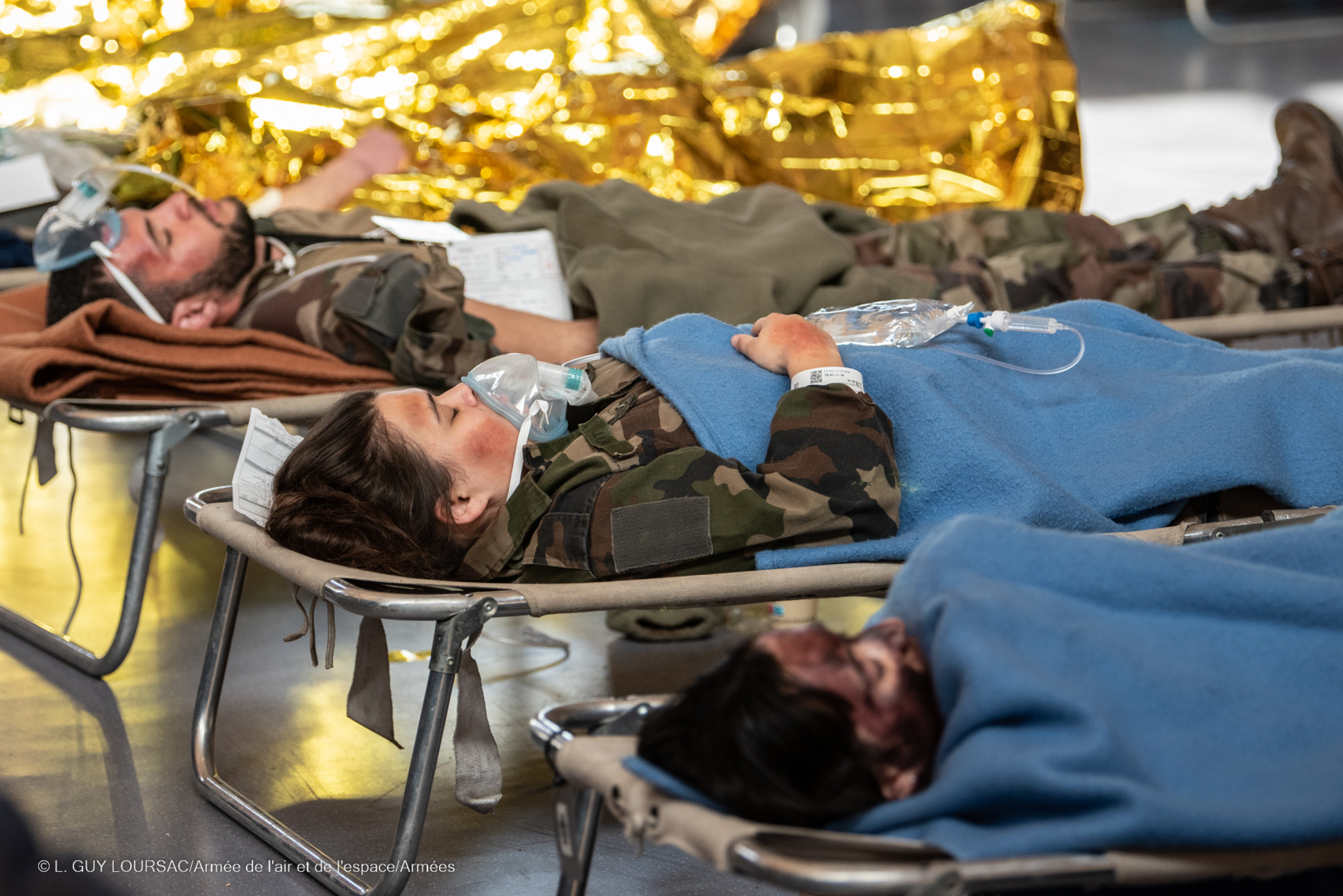 Les blessés fictifs, couchés sur des lits, sont pris en charge par les secours dans le cadre de l'exercice "ELMOS 2023"