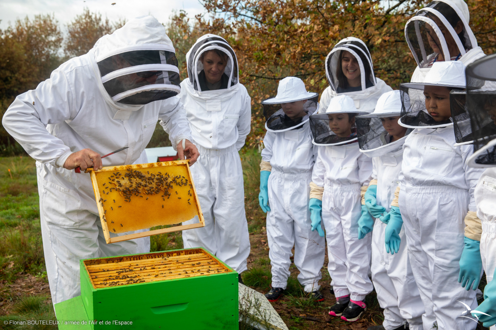 Le colonel Nathalie Picot et les enfants de CE2 de l’école Oscar Auriac devant une ruche d'abeilles. 