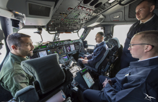 Les élèves échangent avec un équipage à l'intérieur du cockpit de l'A400M.