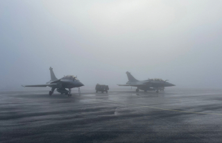 Deux chasseurs côte à côte sur la piste enneigée, dans le brouillard : un Rafale français et un F/A-18 Hornet finlandais