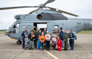 Des jeunes de l'association Rêves de Gosse devant un Puma de l'escadron d'hélicoptères 1/44 "Solenzara"