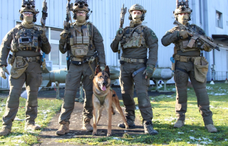 Onyx, chien de recherche d’explosifs et d’armement , se tient aux côtés de quatre commandos du CPA 10