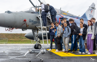 Participants aux portes ouvertes de la BA 106 devant un Mirage 2000 filmant un chien robot
