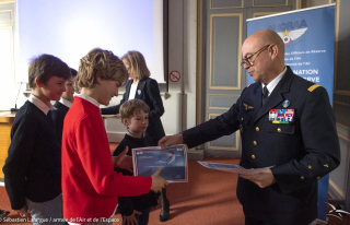 Le général Louis Pena, IAAE, remet un prix aux écoliers pour la réalisation de leur bande dessinée